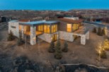 Stunning modern mountain home with expansive windows offering breathtaking views.