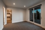 This stunning bedroom boasts a spacious walk-in closet and large sliding glass doors that lead to a private patio, perfect for enjoying the outdoors.