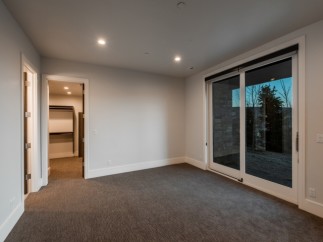 This stunning bedroom boasts a spacious walk-in closet and large sliding glass doors that lead to a private patio, perfect for enjoying the outdoors.