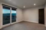 This stunning bedroom boasts a wall of sliding glass doors offering breathtaking mountain views.