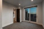 This stunning property boasts a spacious, light-filled room with plush carpeting and large sliding glass doors that offer breathtaking views.