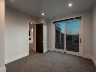 This stunning property boasts a spacious, light-filled room with plush carpeting and large sliding glass doors that offer breathtaking views.
