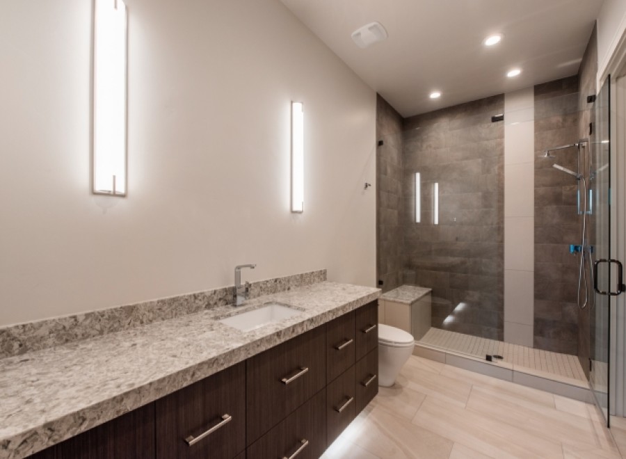 This luxurious bathroom boasts a spacious walk-in shower with modern gray tile and glass enclosure.
