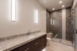 This luxurious bathroom boasts a spacious walk-in shower with modern gray tile and glass enclosure.