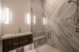 This luxurious bathroom boasts a spacious walk-in shower with a built-in bench and sleek, modern fixtures.