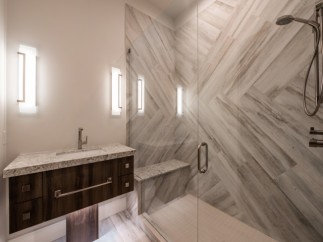 This luxurious bathroom boasts a spacious walk-in shower with a built-in bench and sleek, modern fixtures.