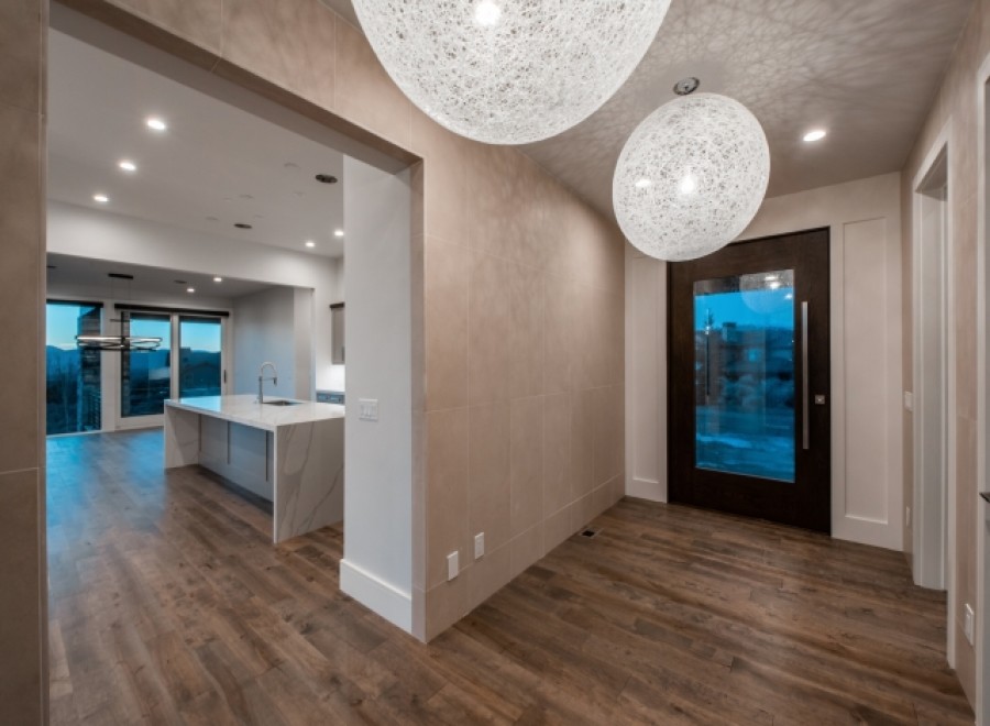 Stunning entryway with modern lighting and hardwood floors.