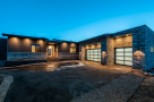 Stunning modern home with a large, attached garage featuring frosted glass garage doors.