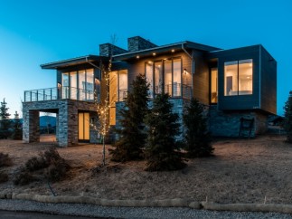 Stunning mountain modern home with expansive windows offering breathtaking views.