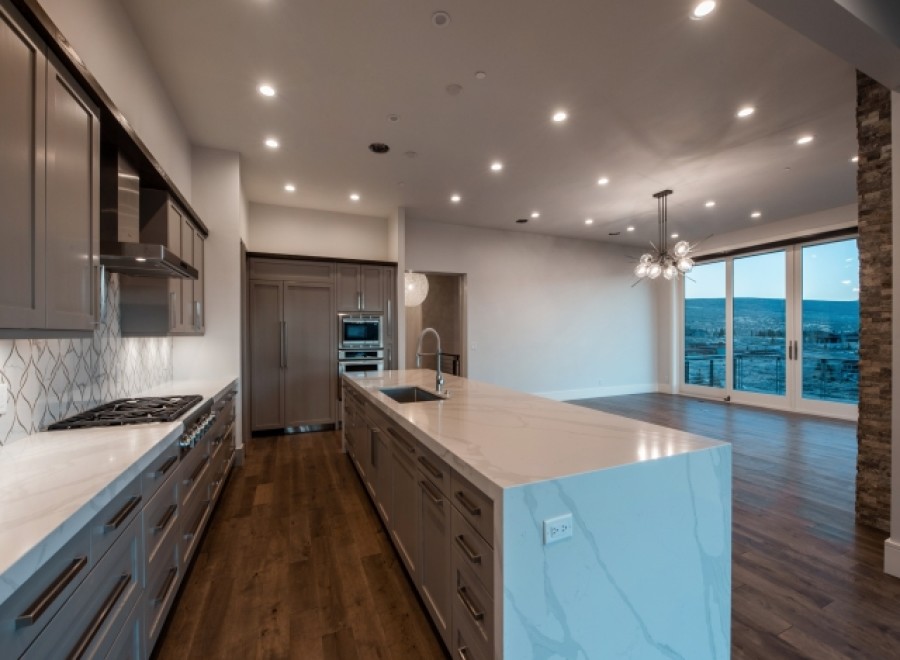 This stunning kitchen boasts modern gray cabinetry, sleek countertops, and high-end appliances.