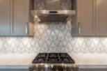 This stunning kitchen boasts sleek stainless steel appliances and modern gray cabinetry.
