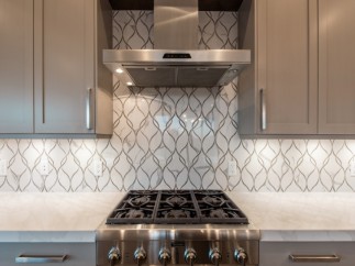 This stunning kitchen boasts sleek stainless steel appliances and modern gray cabinetry.