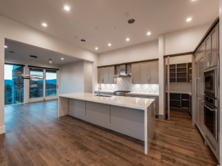 Stunning kitchen with expansive windows offering breathtaking views, complemented by modern cabinetry and high-end appliances.