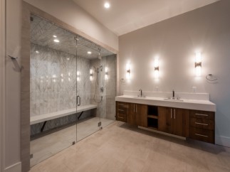 This luxurious bathroom boasts a spacious walk-in shower with a built-in bench and sleek glass enclosure.