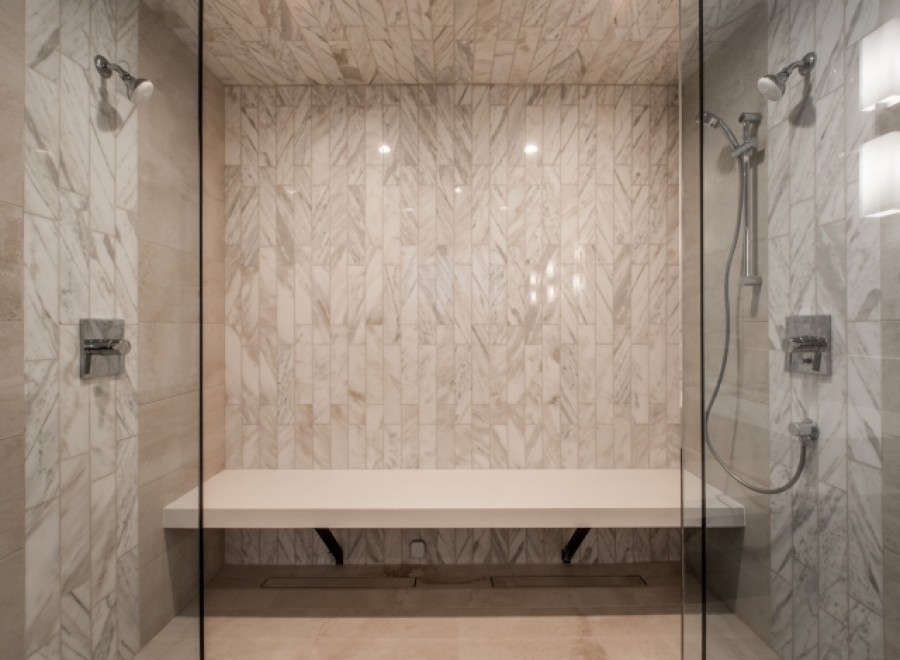 Indulge in this luxurious spa-like shower, featuring a built-in bench for ultimate comfort.
