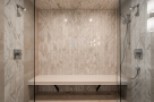 Indulge in this luxurious spa-like shower, featuring a built-in bench for ultimate comfort.