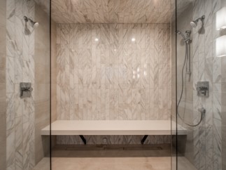 Indulge in this luxurious spa-like shower, featuring a built-in bench for ultimate comfort.