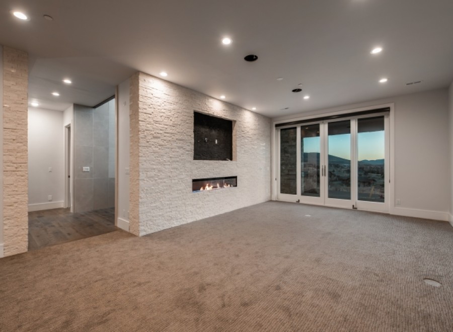 This stunning property boasts a spacious, open-plan basement perfect for entertaining, featuring a modern fireplace and wall-mounted TV.