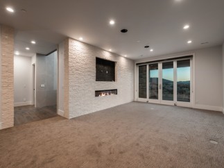 This stunning property boasts a spacious, open-plan basement perfect for entertaining, featuring a modern fireplace and wall-mounted TV.