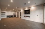 Stunning basement recreation room boasts a built-in bar, fireplace, and plush carpeting.