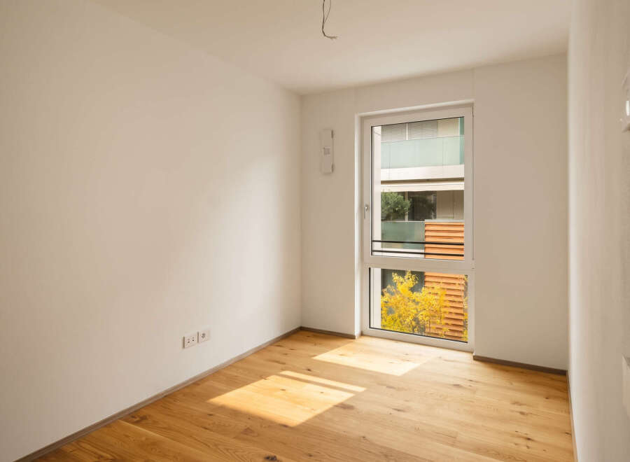 Experience modern living in this unfurnished room featuring a large window that floods the space with natural light.