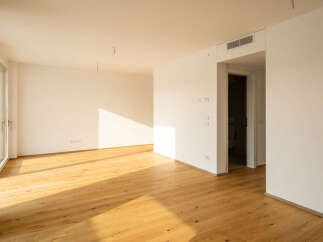 Experience modern living in this bright and airy apartment, featuring a spacious open-plan living area with beautiful hardwood floors that gleam under natural sunlight.