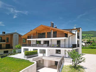 Experience modern alpine living in this stunning multi-story residence, featuring a striking wooden-beamed roof and expansive balconies perfect for enjoying the mountain views.