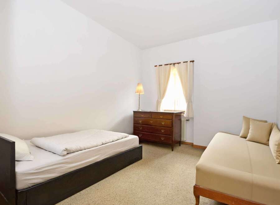 This cozy bedroom features a comfortable bed and a stylish dresser, perfect for a relaxing retreat.