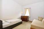 This cozy bedroom features a comfortable bed and a stylish dresser, perfect for a relaxing retreat.