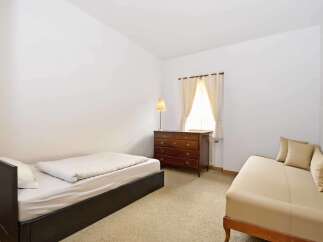 This cozy bedroom features a comfortable bed and a stylish dresser, perfect for a relaxing retreat.