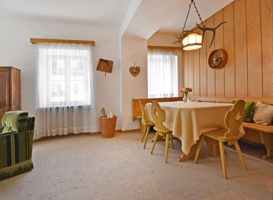 Experience cozy living in this charming dining area, featuring a warm wooden paneling and a comfortable banquette seating.