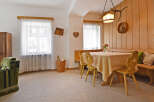 Experience cozy living in this charming dining area, featuring a warm wooden paneling and a comfortable banquette seating.