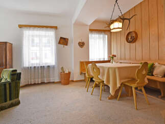 Experience cozy living in this charming dining area, featuring a warm wooden paneling and a comfortable banquette seating.