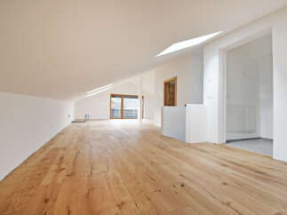 This stunning property boasts a spacious, open-plan living area with beautiful wooden floors and high ceilings, creating an inviting atmosphere.