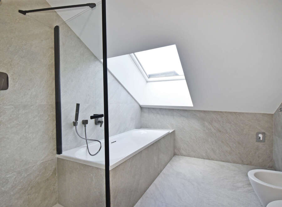 This modern bathroom features a sleek design with a skylight, offering ample natural light.