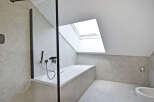 This modern bathroom features a sleek design with a skylight, offering ample natural light.