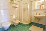 This bathroom features a modern toilet and bidet, complemented by a sleek corner shower enclosure.