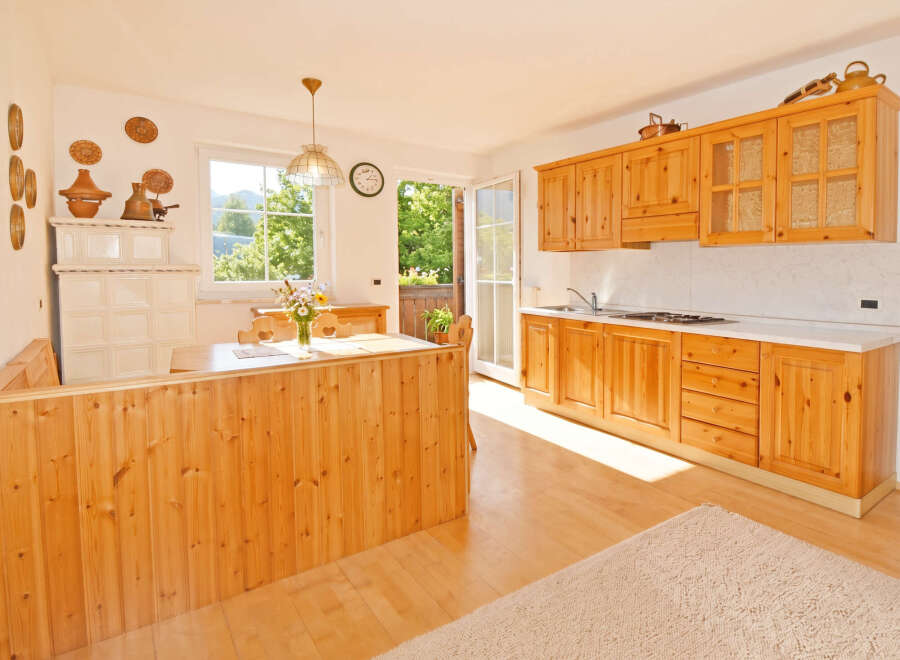 Experience rustic charm in this inviting kitchen, featuring warm wooden cabinetry and a cozy dining nook with a built-in bench.