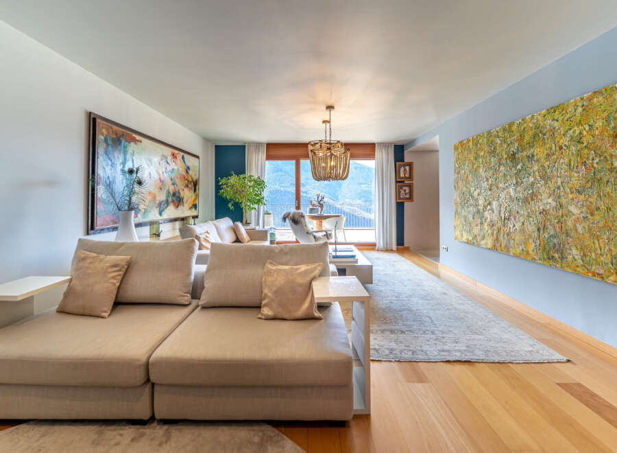 Experience luxury living in this stunning property, featuring a spacious living room with exquisite artwork and a cozy seating area.