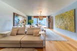 Experience luxury living in this stunning property, featuring a spacious living room with exquisite artwork and a cozy seating area.