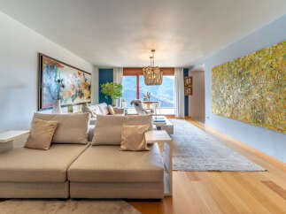Experience luxury living in this stunning property, featuring a spacious living room with exquisite artwork and a cozy seating area.