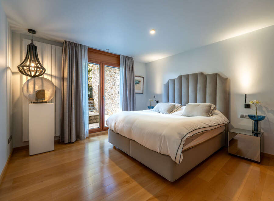 Step into luxury with this stunning bedroom, featuring a plush, upholstered headboard and a serene ambiance.