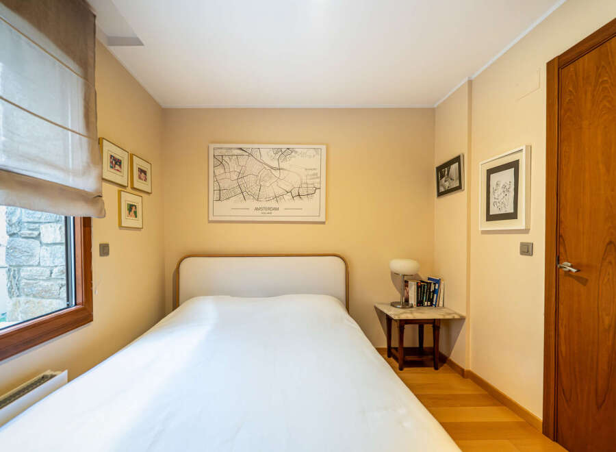 This cozy bedroom features a comfortable bed with a clean white duvet, perfect for a relaxing retreat.