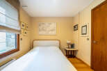 This cozy bedroom features a comfortable bed with a clean white duvet, perfect for a relaxing retreat.