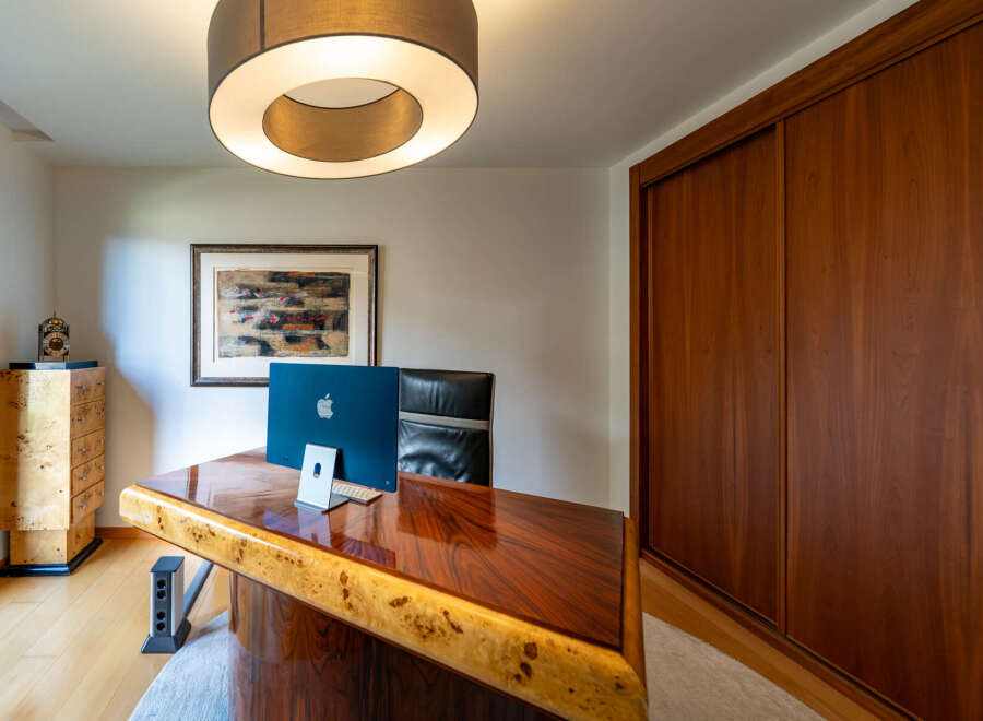 This stunning home office boasts a luxurious, custom-built desk with a unique wood grain design.