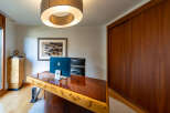 This stunning home office boasts a luxurious, custom-built desk with a unique wood grain design.
