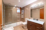 Step into this modern bathroom, featuring a sleek glass shower enclosure and a stylish vanity.