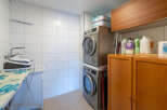 This laundry room features a modern design with a stacked washer and dryer, maximizing space efficiency.