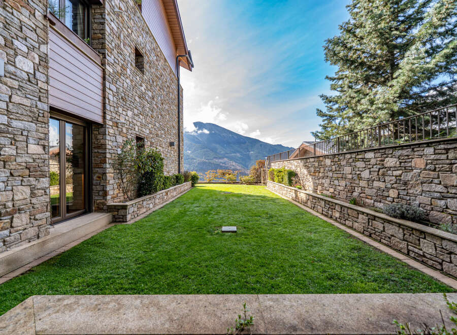Discover the charm of this stunning property, featuring a beautifully manicured lawn and a backdrop of majestic mountains.