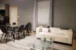 This modern living space boasts a sleek design with a comfortable white sofa and a glass-top coffee table.